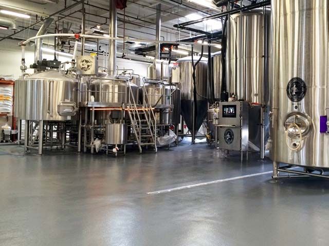 Seamless flooring in a brewery with stainless steel fermentation tanks