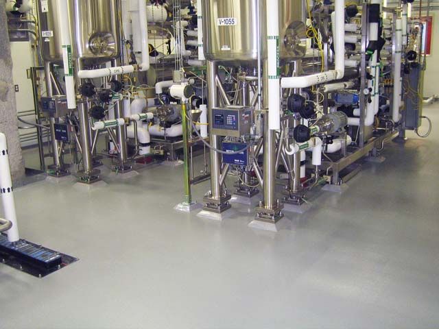 Epoxy-coated floor beneath stainless process equipment in a pharmaceutical plant