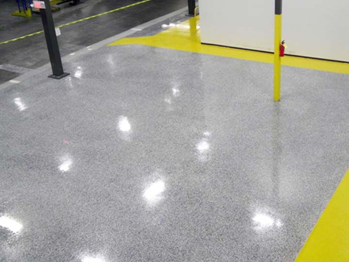 Gray epoxy floor with yellow safety striping in a government facility